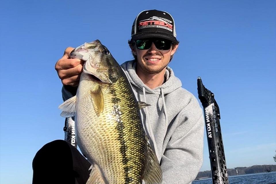 Chase Carey holding a bass on the lake